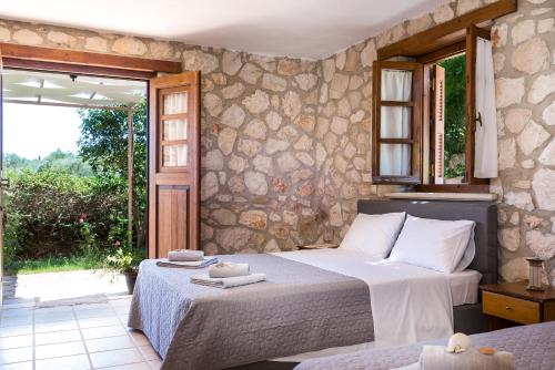 a bedroom with two beds and a large window at Abeloklima country house in Vasilikos