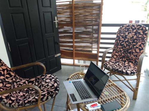 un ordinateur portable assis sur une table avec des chaises dans l'établissement Varkala Days Home Stay, à Varkala