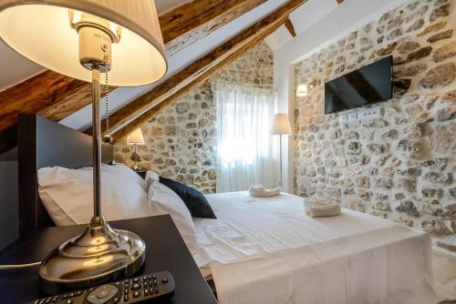 a bedroom with a bed and a lamp on a table at Luxury Deluxe Apartment in Dubrovnik