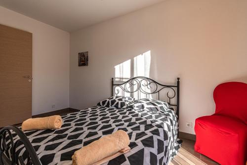 a bedroom with a black and white bed and a red chair at L'Orinaju in Oletta