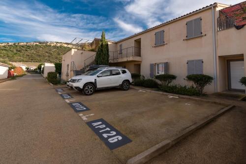 a white car parked in a parking lot next to a building at L'Orinaju in Oletta