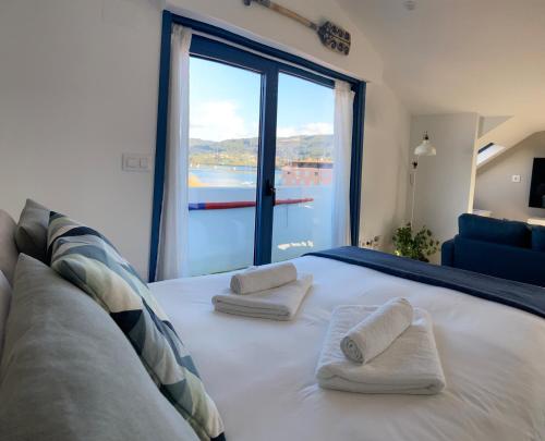 a bedroom with a large bed with two pillows on it at O Faiado by Oktheway in Puentedeume