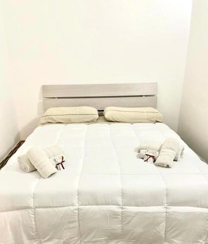 a bed with white sheets and towels on it at JASMINE HOUSE in Triggiano