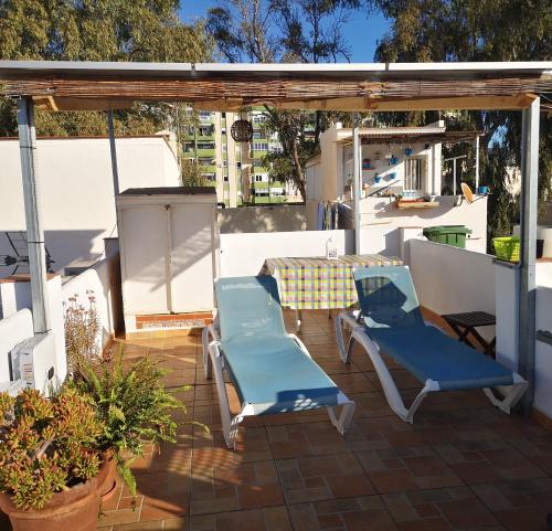 patio z 2 krzesłami i stołem na dachu w obiekcie Banda del Mar 1 w Maladze