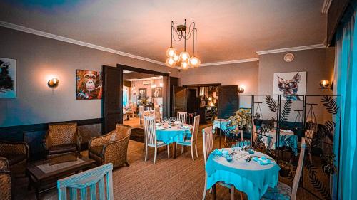 a restaurant with tables and chairs and a chandelier at Le Chalet Montégut in Moulins