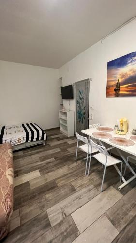 ein Wohnzimmer mit einem Tisch, Stühlen und einem Bett in der Unterkunft Studio près de la mer in Port-Vendres