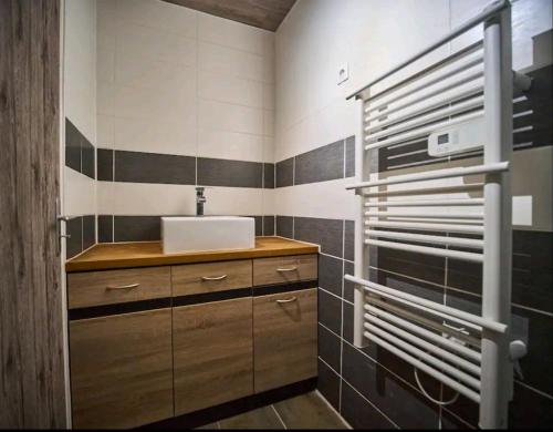 a bathroom with a sink and black and white tiles at Gite vomecourtois 