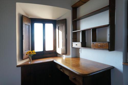 a kitchen with a wooden counter and two windows at Ar Convént B&B in Bigorio