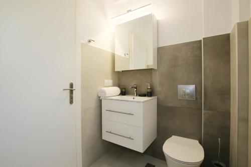 a bathroom with a white toilet and a sink at Sunset Sea View Villa 10 in Afionas