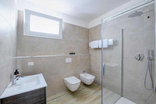 y baño con ducha, aseo y lavamanos. en Residence Sunlight en Lido di Jesolo