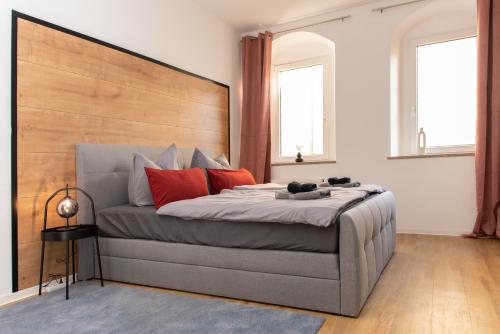 a bedroom with a large bed with red pillows at Stilvolles Apartment direkt am Marktplatz / Netflix und WiFi in Frankenberg