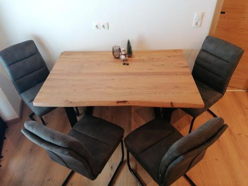 einen Esstisch mit Stühlen und einem Holztisch in der Unterkunft Apart Alpenflair in Umhausen
