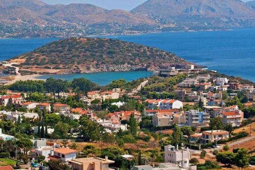 a town on a hill next to the water at villa in Agios Nikolaos Anavyssos in Áyios Yeóryios
