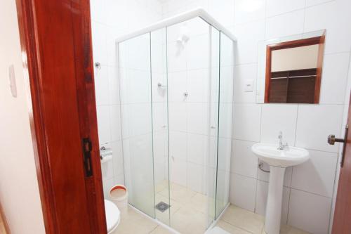 W łazience znajduje się prysznic, toaleta i umywalka. w obiekcie Hotel Perez w mieście Pouso Alegre