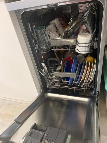 a dishwasher filled with dishes and utensils at Slunný byt v Jizerských horách 5 postelí in Tanvald