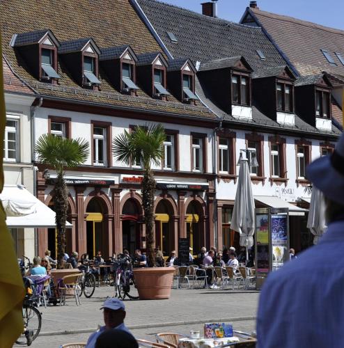 a group of people sitting at tables in front of a building at Maximilian in Speyer