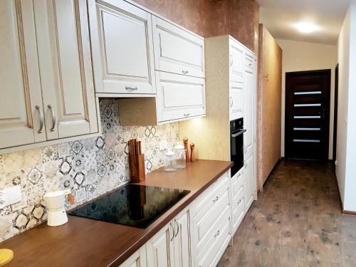 a kitchen with white cabinets and a black counter top at Flowers in the attic in Żywiec