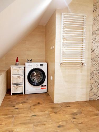 a laundry room with a washing machine and a window at Flowers in the attic in Żywiec