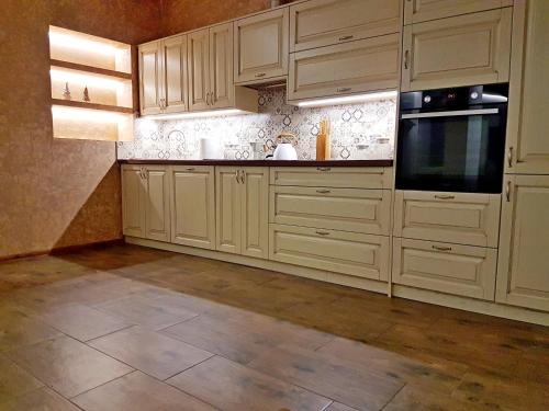 a kitchen with white cabinets and a tile floor at Flowers in the attic in Żywiec