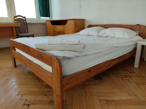 ワルシャワにあるSmolna Towerの木製ベッド(白いシーツ、枕付)
