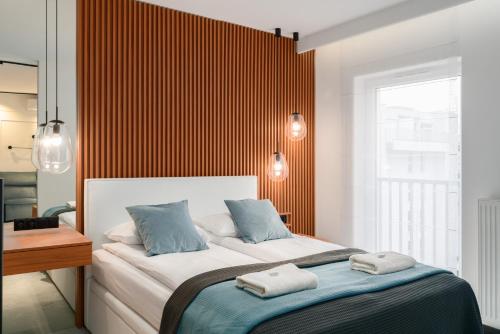 1 dormitorio con 1 cama grande y 2 toallas. en Wilczak Apartment with FREE GARAGE Poznań by Renters, en Poznan