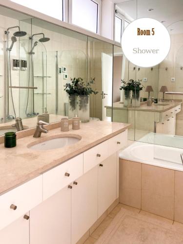 a bathroom with a sink and a shower at Casa dos Pinheiros 109 - Private Villa with pool & heated SPA in Porto