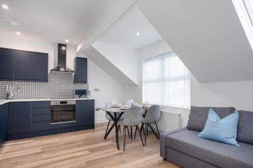a kitchen and living room with a table and a couch at Central Avenue Apartment in Belfast
