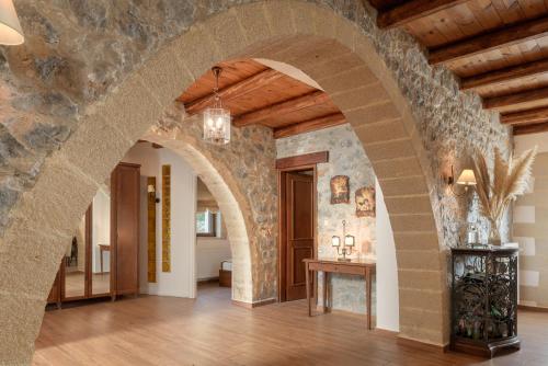 an archway in a room with a stone wall at Geroulios Kastro, a Grand Estate, By ThinkVilla in Vatoudhiáris