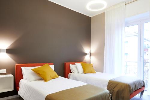 two beds with yellow pillows in a room at GREEN RIBBON in Milan