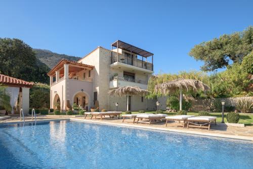 a villa with a swimming pool and a house at Geroulios Kastro I & II, a Grand Estate, By ThinkVilla in Vatoudhiáris