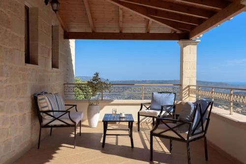 a patio with chairs and a table on a balcony at Geroulios Kastro, a Grand Estate, By ThinkVilla in Vatoudhiáris