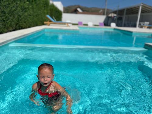 a baby swimming in a swimming pool at Blue Sky Transalpina in Săsciori