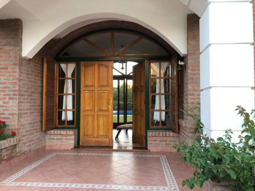 una entrada a una casa con puerta de madera en Las Lavandas - Hermoso Chalet en Villa de Merlo con vista a las sierras en Merlo