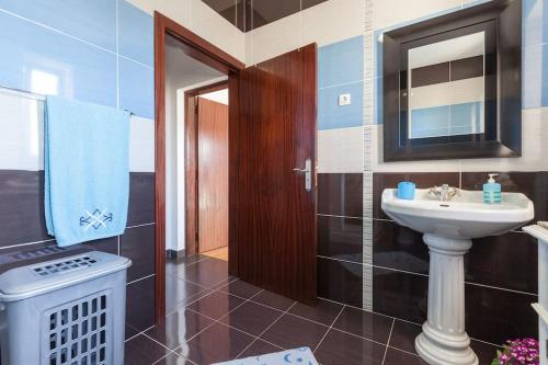 a bathroom with a sink and a toilet and a mirror at Casa das Gazânias in Cabeceiras de Basto