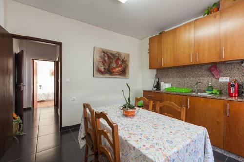 a kitchen with a table and chairs and a kitchen with a counter at Casa das Gazânias in Cabeceiras de Basto