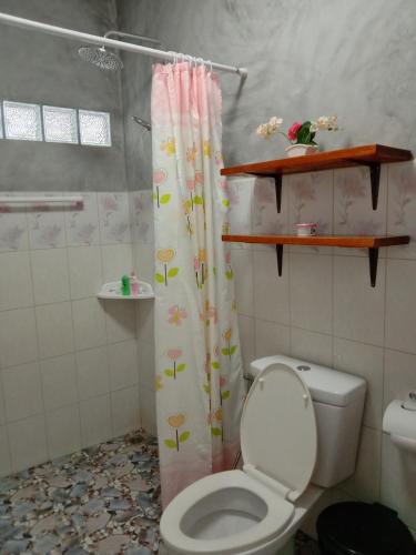 a bathroom with a toilet and a shower curtain at Goodluck village house in Koh Mook