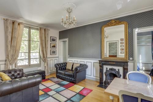 uma sala de estar com um sofá e uma lareira em Aux Loges de L'orangerie em Versailles