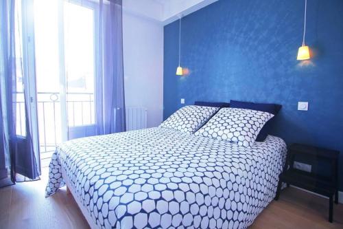 - une chambre avec un grand lit et un mur bleu dans l'établissement LE LAC au DUC, à Vannes