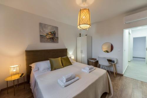 a bedroom with a large bed with towels on it at LUXURY VILLA ŠENTADA in Vinišće