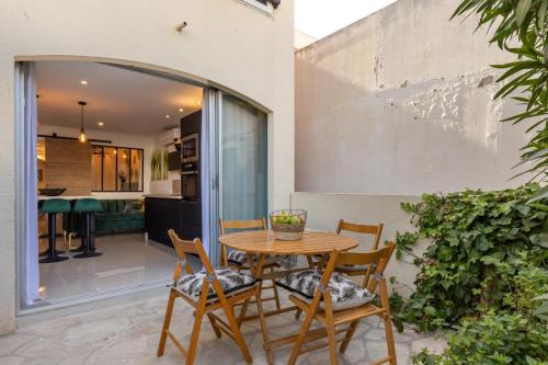 un patio avec une table et des chaises en bois dans l'établissement Cap d'Agde Studio - Port, au Cap d'Agde
