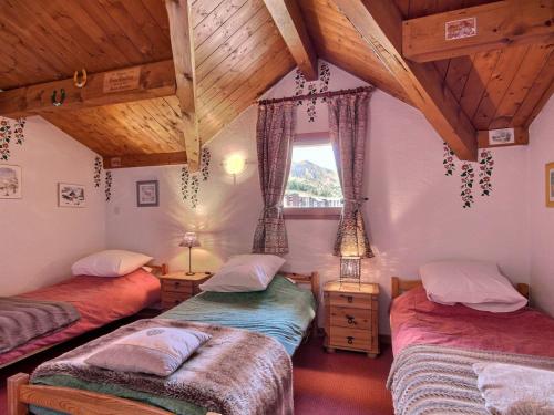 Cette chambre mansardée comprend 3 lits et une fenêtre. dans l'établissement Chalet pour 11 personnes au pied des pistes à La Plagne, avec garage et balcons - FR-1-455-202, à La Plagne Tarentaise