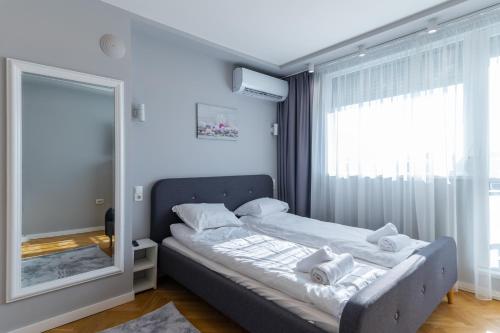 een slaapkamer met een bed en een grote spiegel bij Cosy 1BD Flat with a Lovely Balcony in Sofia