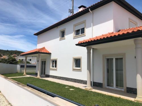 a white house with a red roof at Torrezinha- Moradia Moderna em condomínio com piscina in Salir de Porto