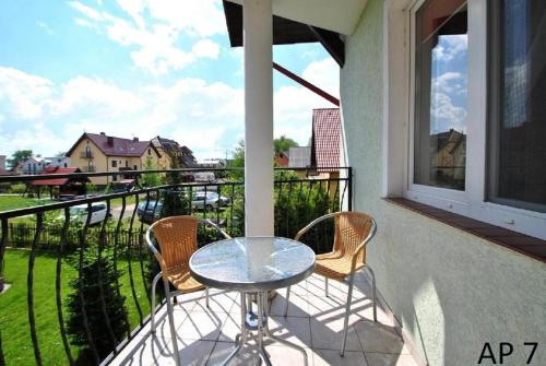 una mesa y sillas en un balcón con vistas en Apartament Rybacka 84/7, en Krynica Morska