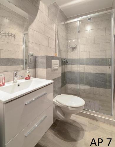 y baño con aseo, lavabo y ducha. en Apartament Rybacka 84/7, en Krynica Morska