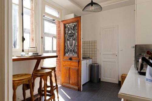 a kitchen with a wooden door and a table and chairs at Les Tournelles in Courbevoie