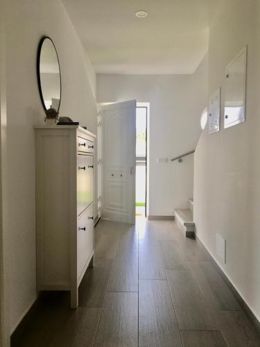 a white kitchen with a mirror on the wall at Torrezinha- Moradia Moderna em condomínio com piscina in Salir de Porto