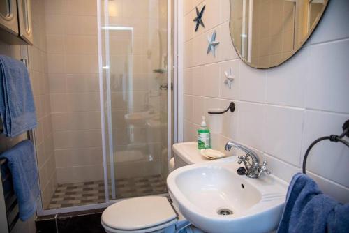 a bathroom with a shower and a sink and a toilet at Rothesay in Knysna