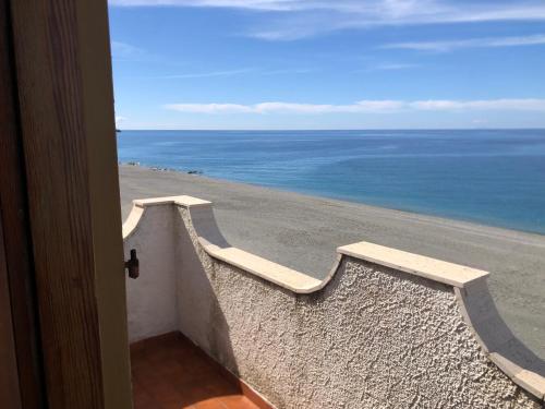 a door to a room with a view of the ocean at Stella Marina Terrace in Belmonte Calabro