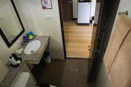a bathroom with a sink and a toilet and a mirror at Sky Villa Hua Hin Guesthouse - Adults-Only in Hua Hin